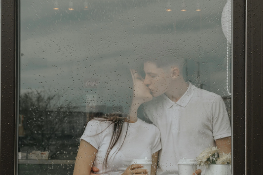 Couple looking out of the window together on a rainy day