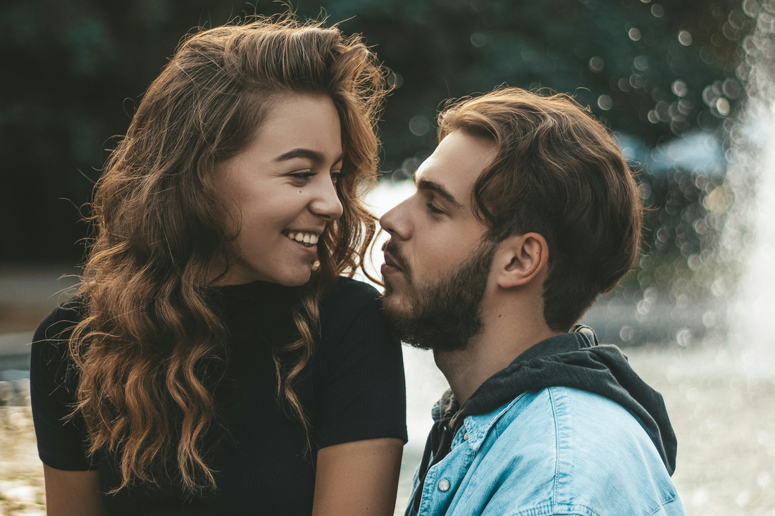 Happy young couple sitting outside having a deep conversation